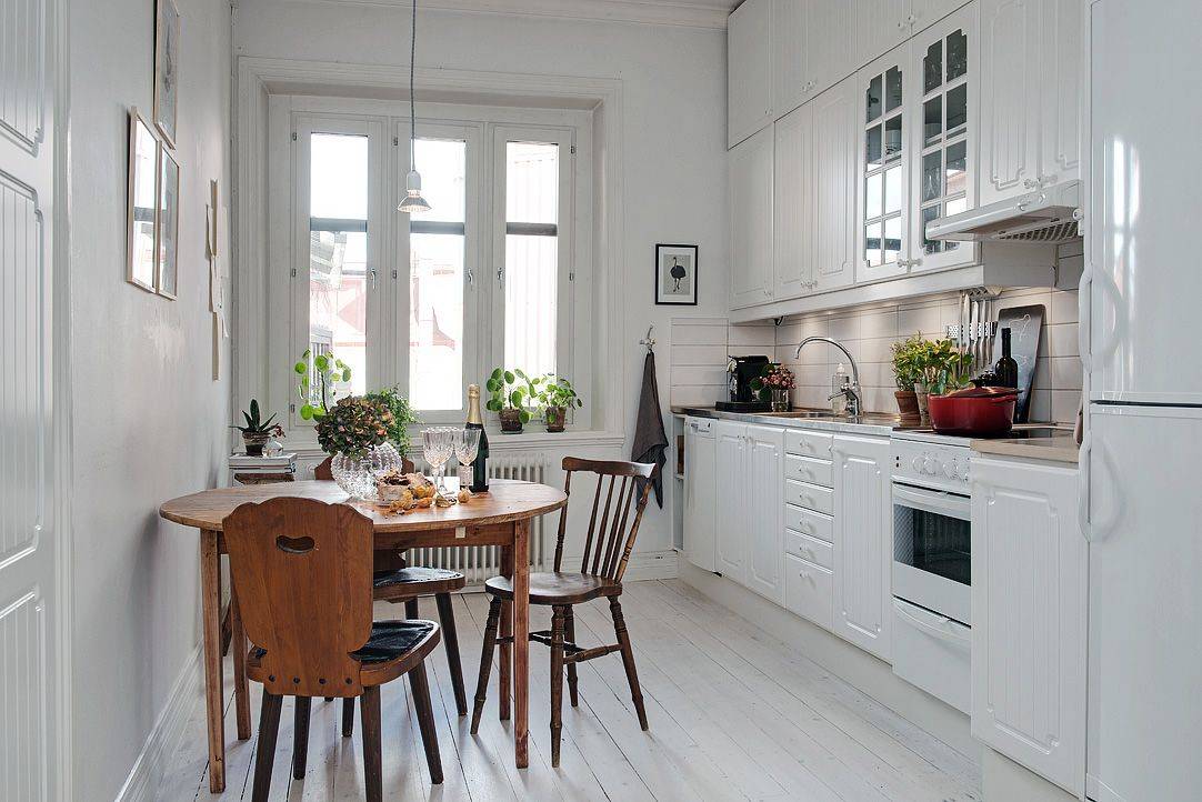 Стильная белая кухня 7 кв в скандинавском стиле с круглым столом