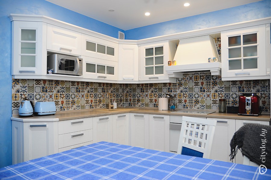 Дизайн белой кухни 12 кв.м с голубыми стенами и яркой плиткой на фартуке